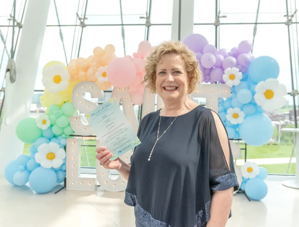 mother smiling holding a program during a mothers day event